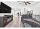 Expansive living room flows into kitchen and dining area, showcasing a comfortable sectional sofa and modern entertainment center at 33854 Floating Heart Ct, Wesley Chapel, FL 33545