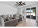 Living room boasts a plush sectional sofa, neutral color palette, and access to outdoor patio through sliding glass doors at 33854 Floating Heart Ct, Wesley Chapel, FL 33545
