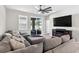 Comfortable living room featuring a large sectional sofa, contemporary ceiling fan, and sliding glass doors to the patio at 33854 Floating Heart Ct, Wesley Chapel, FL 33545