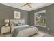 Stylishly staged bedroom with modern decor, ceiling fan, and sun-filled window at 3902 Shoreside Cir, Tampa, FL 33624
