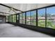 Enclosed sunroom with large windows offering serene views of a pond and lush landscaping at 3902 Shoreside Cir, Tampa, FL 33624