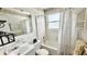 A bright bathroom featuring a shower-tub combo with white tile, a window, and vanity at 416 73Rd N Ave # 206, St Petersburg, FL 33702