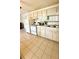 A kitchen features tile flooring, white appliances, cabinets, sink, and a window with natural light at 416 73Rd N Ave # 206, St Petersburg, FL 33702