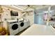 A communal laundry room is equipped with washers, dryers, and ample folding space at 416 73Rd N Ave # 206, St Petersburg, FL 33702