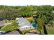 Aerial view of the property showcasing a backyard pool and fire pit area, surrounded by lush trees for privacy at 4307 Foxglen Ln, Tampa, FL 33624