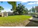 Spacious backyard with lush green grass, a storage shed, and a patio set near the pool at 4307 Foxglen Ln, Tampa, FL 33624