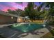 Stunning backyard at dusk with a sparkling pool and a lush green lawn, creating a serene outdoor retreat at 4307 Foxglen Ln, Tampa, FL 33624