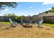 Cozy backyard fire pit area with gravel, surrounded by blue Adirondack chairs and wooden fencing at 4307 Foxglen Ln, Tampa, FL 33624