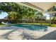 Relaxing backyard with sparkling pool, lush greenery, and lounge seating; perfect for enjoying the outdoors at 4307 Foxglen Ln, Tampa, FL 33624