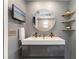 Modern bathroom featuring a double sink vanity, decorative shelves, and a mounted television at 4307 Foxglen Ln, Tampa, FL 33624