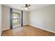 Bright bedroom with hardwood floors, a ceiling fan, and a large window with blue curtains at 4307 Foxglen Ln, Tampa, FL 33624