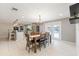 Bright dining room features modern chandelier, an open floorplan, and easy access to the pool through glass doors at 4307 Foxglen Ln, Tampa, FL 33624