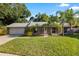 Charming single-story home features a lush front yard and well-maintained landscaping with tropical palm trees at 4307 Foxglen Ln, Tampa, FL 33624