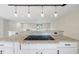 Granite kitchen island with sleek cooktop, modern pendant lights, and open layout flowing to the living area at 4307 Foxglen Ln, Tampa, FL 33624
