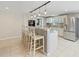 Kitchen island boasts barstool seating, modern pendant lighting, and stainless appliances for a functional cooking space at 4307 Foxglen Ln, Tampa, FL 33624
