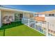 Upper balcony featuring synthetic turf, white railing, and views of the pool and surrounding neighborhood at 451 Palm Ne Is, Clearwater Beach, FL 33767
