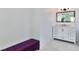 Bathroom features a white vanity with marble countertop, white cabinets and drawers and a purple bench seat at 451 Palm Ne Is, Clearwater Beach, FL 33767