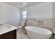 Bathroom features a modern soaking tub, tiled accent wall and dark wood vanity with white basin sink at 451 Palm Ne Is, Clearwater Beach, FL 33767