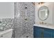 Stylish bathroom with a unique tiled shower, vanity with marble countertop, and updated fixtures at 451 Palm Ne Is, Clearwater Beach, FL 33767