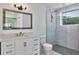 Modern bathroom with white vanity, white toilet and unique shower with glass surround and patterned tile walls at 451 Palm Ne Is, Clearwater Beach, FL 33767