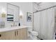 Modern bathroom featuring a wood vanity, marble wall tile, sleek fixtures, and a shower with curtain at 468 44Th N Ave, St Petersburg, FL 33703