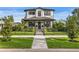 Inviting two-story home with a manicured front yard, black fence, and covered front porch at 468 44Th N Ave, St Petersburg, FL 33703