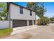 This two-car garage boasts a modern exterior with dark doors and white siding and a backyard alley at 468 44Th N Ave, St Petersburg, FL 33703
