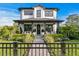 Charming two-story home features a well-manicured front yard with lush landscaping and a black iron fence at 468 44Th N Ave, St Petersburg, FL 33703