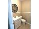 A neutral bathroom features a toilet, sink, vanity and round mirror at 5110 Corvette Dr, Tampa, FL 33624