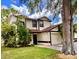 Inviting two-story home with a well-kept lawn, lush landscaping, and attached two-car garage at 5110 Corvette Dr, Tampa, FL 33624