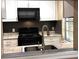 The kitchen features white cabinets and black appliances at 5110 Corvette Dr, Tampa, FL 33624