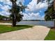 Lake view with a boat ramp, grassy shoreline, and clear blue skies at 5110 Corvette Dr, Tampa, FL 33624