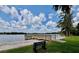 Scenic view of community lake with a wooden pier, sandy beach, and bench at 5110 Corvette Dr, Tampa, FL 33624
