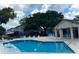 Community pool surrounded by lounge chairs, shaded umbrellas, and a nearby clubhouse at 5110 Corvette Dr, Tampa, FL 33624