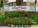 Community sign reading 'LeClare Shores,' a deed-restricted community, surrounded by colorful flower beds at 5110 Corvette Dr, Tampa, FL 33624