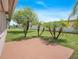 Backyard area featuring lush landscaping with palm trees and a concrete patio, perfect for outdoor enjoyment at 5390 Magnolia N Trl, Pinellas Park, FL 33782