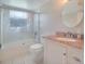 Bathroom features a granite countertop, round mirror, and tiled shower at 5390 Magnolia N Trl, Pinellas Park, FL 33782