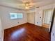 Bedroom featuring hardwood floors, a window with blinds, and a ceiling fan at 5390 Magnolia N Trl, Pinellas Park, FL 33782