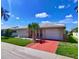 Delightful single-story home with a red driveway, green lawn, and a decorative palm tree at 5390 Magnolia N Trl, Pinellas Park, FL 33782