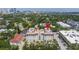 Aerial view of a beautiful building with a red pin marker and surrounding lush greenery against the backdrop of the city skyline at 610 S Rome Ave # 602, Tampa, FL 33606