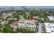 Stunning aerial view of a white condo building with a red tile roof in an urban area with palm trees at 610 S Rome Ave # 602, Tampa, FL 33606
