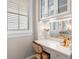 Elegant bathroom vanity area with a chair, makeup mirror, and decorative lamps at 610 S Rome Ave # 602, Tampa, FL 33606