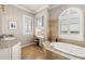 A luxurious bathroom featuring a soaking tub with travertine tile, a makeup vanity, and granite countertop at 610 S Rome Ave # 602, Tampa, FL 33606