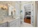 Elegant bathroom showcasing patterned wallpaper, a chandelier, and marble countertops at 610 S Rome Ave # 602, Tampa, FL 33606