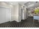 Hallway with elevator access featuring neutral tones, wall trim, and geometric flooring for a modern and appealing look at 610 S Rome Ave # 602, Tampa, FL 33606