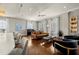Bright living room featuring hardwood floors, a leather sofa, piano, and refined finishes at 610 S Rome Ave # 602, Tampa, FL 33606