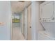 Hallway featuring multiple closets and a stacked washer and dryer, leading to lanai with view at 635 30Th W Ave # F309, Bradenton, FL 34205