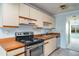 Traditional kitchen featuring wood-trimmed cabinets and countertop with an electric range and a white range hood at 635 30Th W Ave # F309, Bradenton, FL 34205