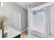 Bright bathroom with a white tub, shower, toilet, and vanity with a large mirror and decorative plants at 7809 E 114Th Ave, Temple Terrace, FL 33617