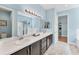 Bright bathroom with double sink vanity, large mirror, and walk in shower with glass doors at 7809 E 114Th Ave, Temple Terrace, FL 33617